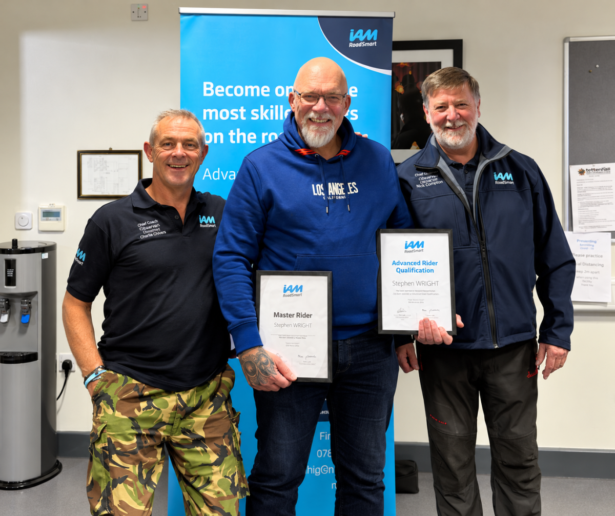 Steve Wright holding his Masters Bike and Advanced Rider certificates with two NSADR representatives